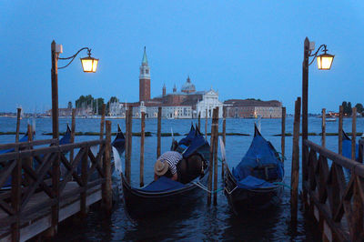 Boats moored on wooden post in water