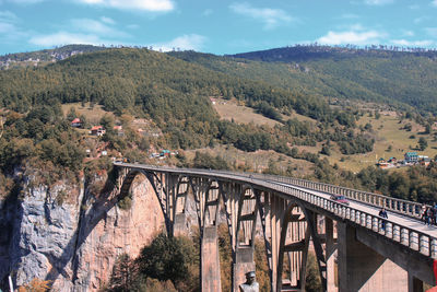 Scenic view of bridge over mountains against sky
