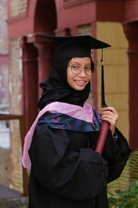 Portrait of woman looking away with convocation suit during her graduation