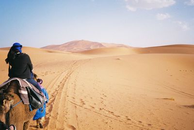 Rear view of man on sand dune