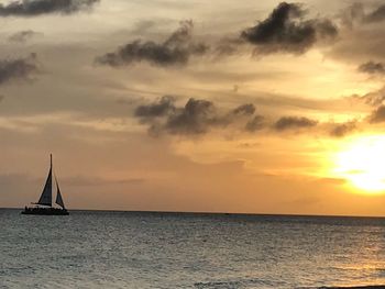 Sailboat sailing on sea against sky during sunset