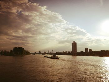 Scenic view of river by buildings against sky