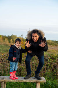 Full length of father and son standing on field