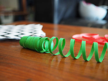 Close-up of green paper curl on table