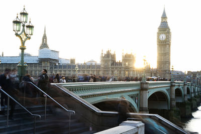 Bridge over river in city against clear sky