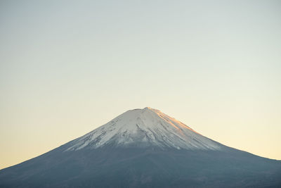 Snowcapped mountain against clear sky during winter