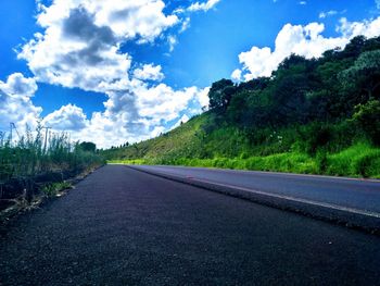 Road amidst trees against sky