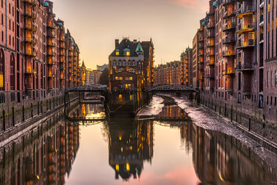 Bridge over canal amidst buildings in city