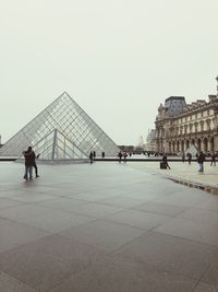 Tourists in museum against sky in city