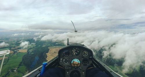 Close-up of airplane cockpit against clouds