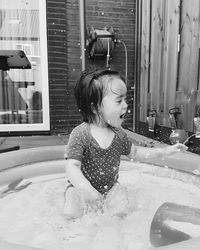 Cute girl splashing water in wading pool