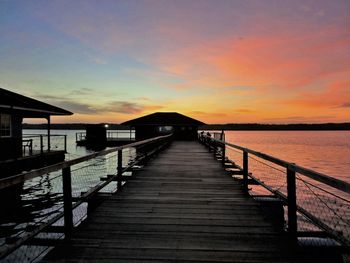 Pier over sea against sky during sunset