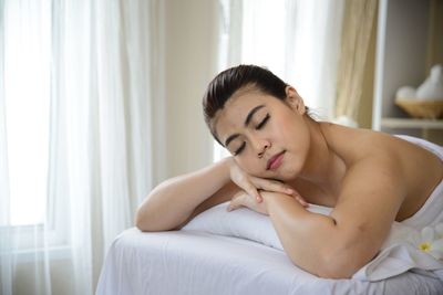 Young woman lying on bed