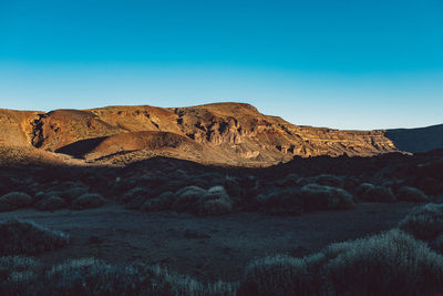 Scenic view of rocky mountains against clear blue sky