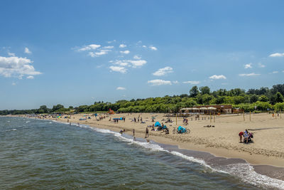 People on beach against sky