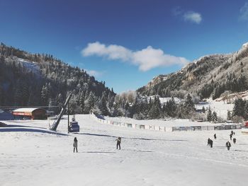 People on snow covered mountain against sky