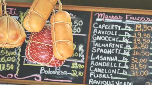 Low angle view of breads for sale against menu in store