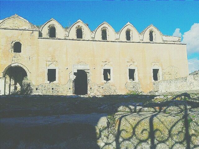 architecture, built structure, building exterior, clear sky, blue, water, arch, sunlight, history, day, outdoors, sky, building, low angle view, facade, no people, window, house, old, travel destinations