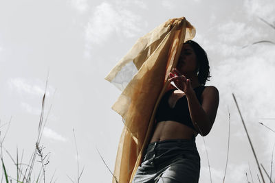 Low angle view of woman standing against sky