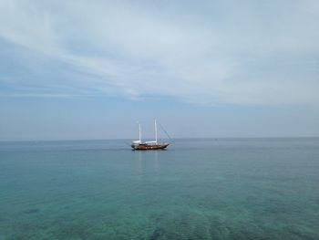 Sailboat in sea against sky