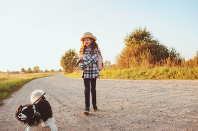 Man with dog on road against sky