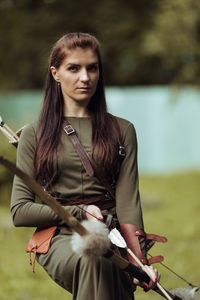 Portrait of beautiful archer while standing outdoors