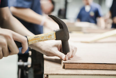 Cropped image of carpenter making furniture in carpentry workshop