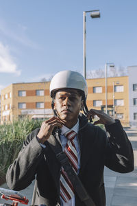 Young businessman putting on helmet riding an electric scooter