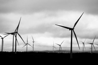 Low angle view of windmills against sky