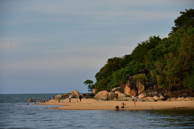 People on beach against sky