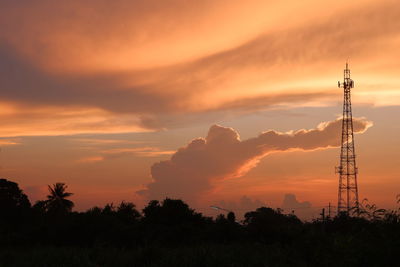 Silhouette of electricity pylon against sky during sunset