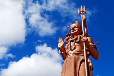 Low angle view of angel statue against sky