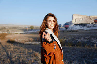 Young woman standing against mountain