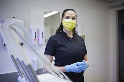 Female dentist standing in office