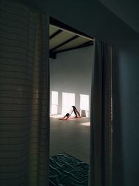 Woman looking through window at home