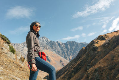 Woman standing on mountain against sky