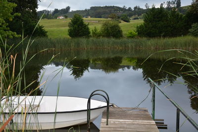 Scenic view of lake, boat and footbridge