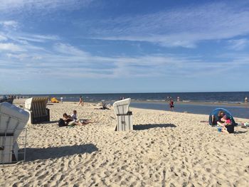 People at beach against sky