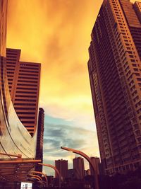 Low angle view of skyscrapers against sky during sunset