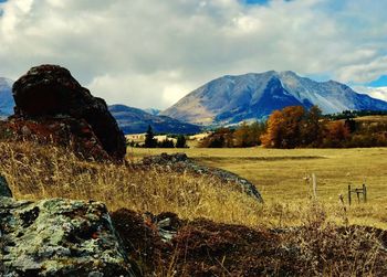 Scenic view of field and mountains against sky