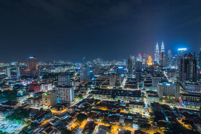 Illuminated cityscape against sky at night