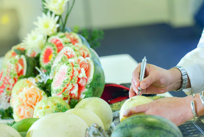 Midsection of person with fruits on plant