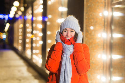 Portrait of man standing in illuminated park during winter