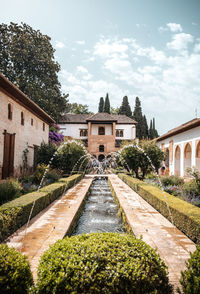 Alhambra gardens and fountains against blue sky. arabic architecture in granada, spain.