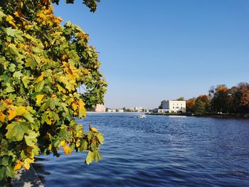 Scenic view of river by buildings against clear sky