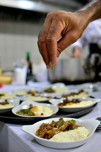 Close-up of hand seasoning food