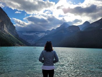 Rear view of man standing by lake