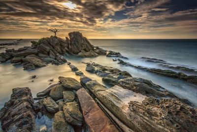 Scenic view of ocean against cloudy sky