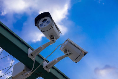 Low angle view of telephone pole against blue sky