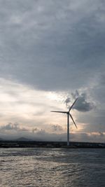 Wind turbines in sea against sky